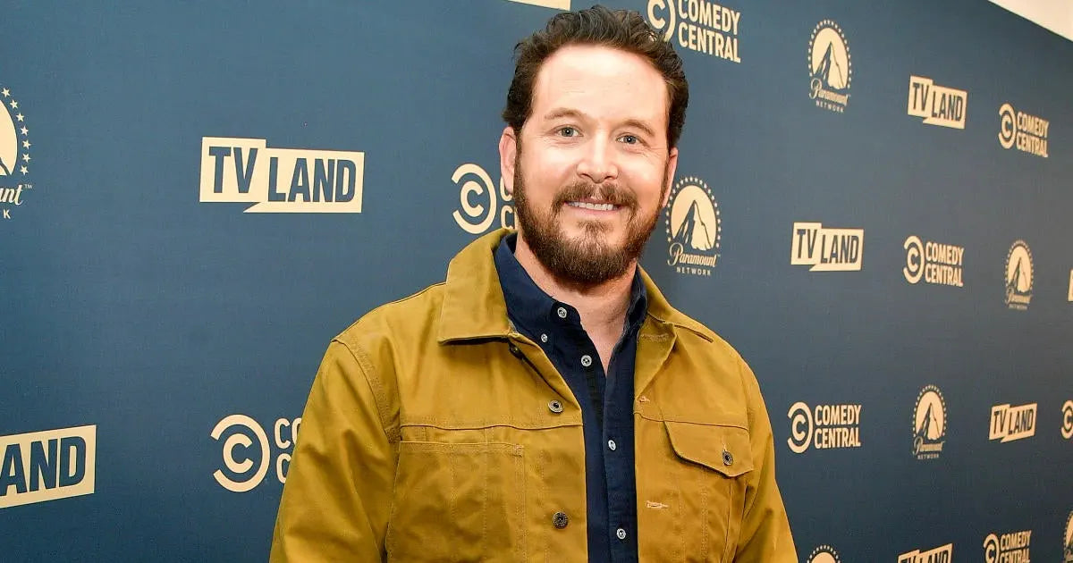 Rip Wheeler standing in front of a blue backdrop with TV Land and Comedy Central logos.