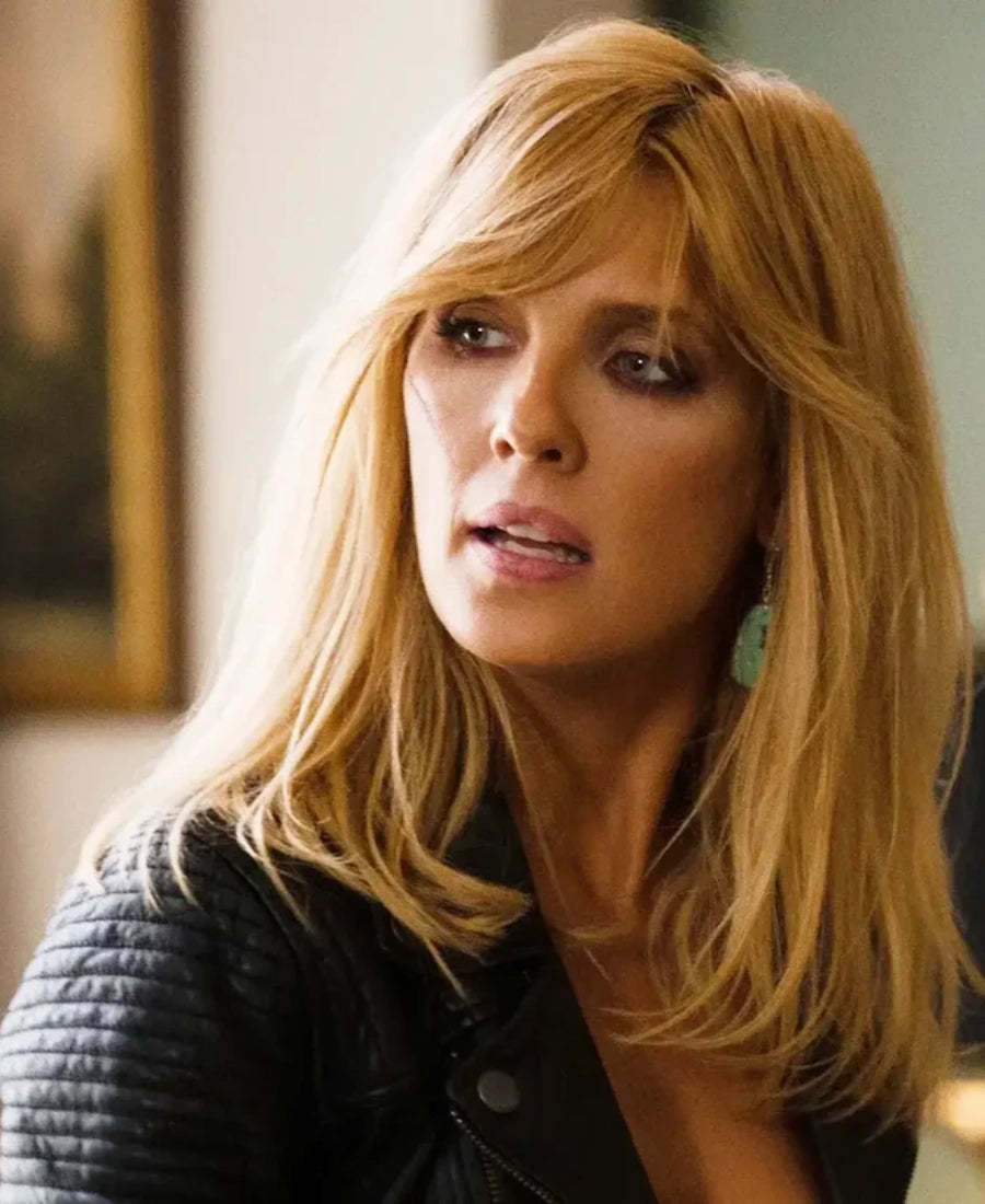Beth Dutton with blonde hair and a black leather jacket top in an indoor setting