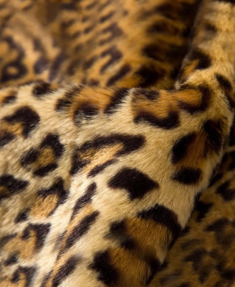 Close-up of leopard print fabric with brown, black, and beige colors.
