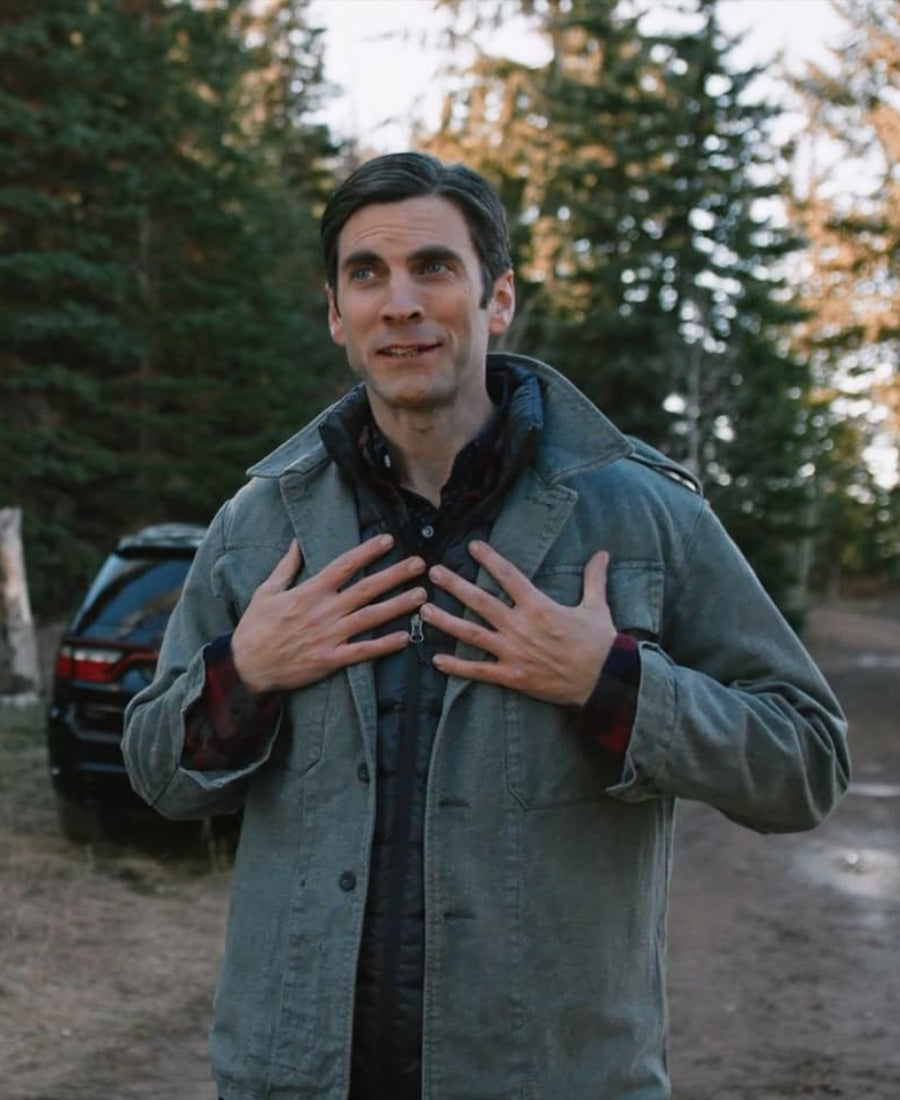 Jamie Dutton Grey cotton jacket  standing outdoors with trees.