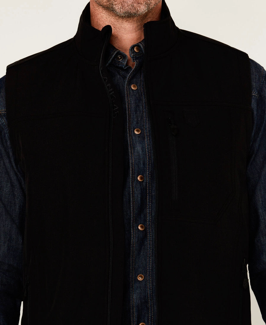 Rip Wheeler wearing a black vest over a dark shirt with a white background