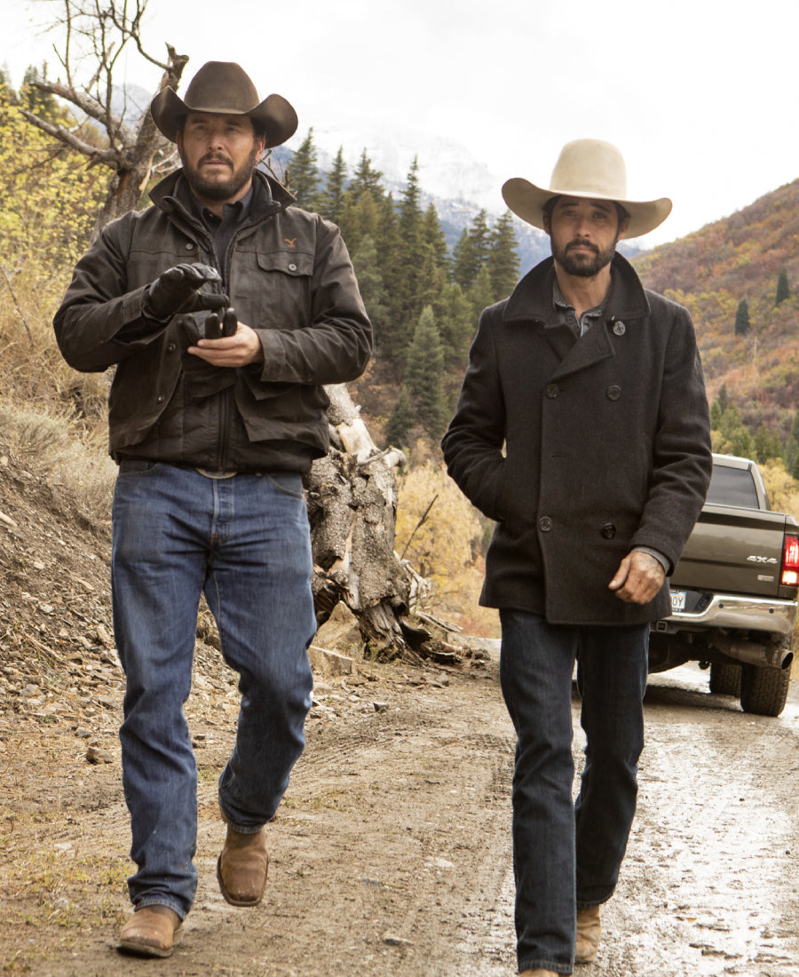 Walker Yellowstone Ryan Bingham and Rip Black Pea Coat men in cowboy hats walking on a dirt road