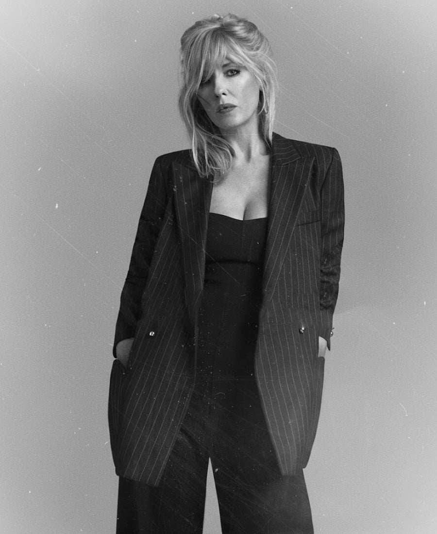 Beth dutton wearing a black pinstripe suit.