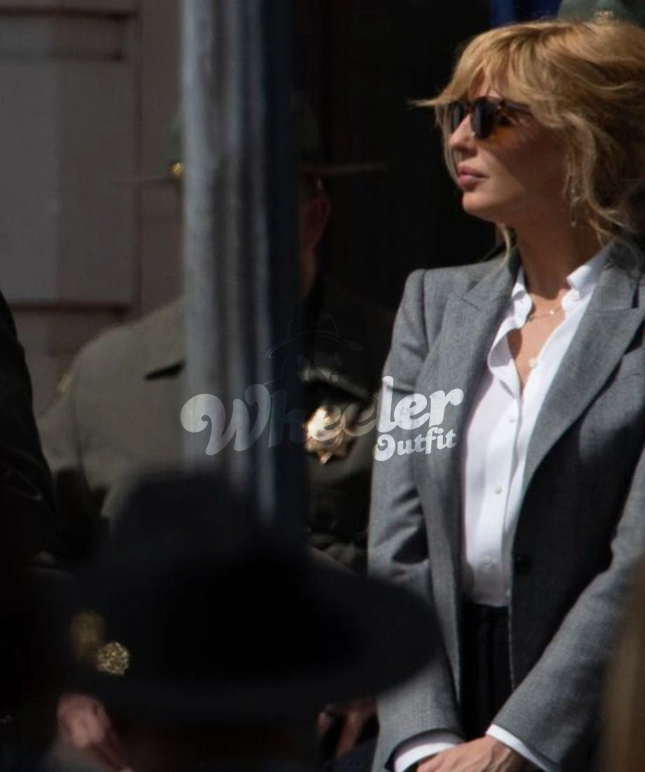 Person wearing a gray blazer with 'Beth Dutton' branding, outdoors.