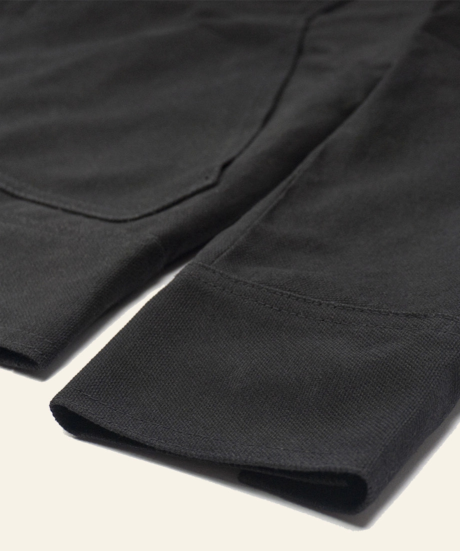 Rip Wheeler Jacket Close-up of black fabric with a textured pattern on a light background