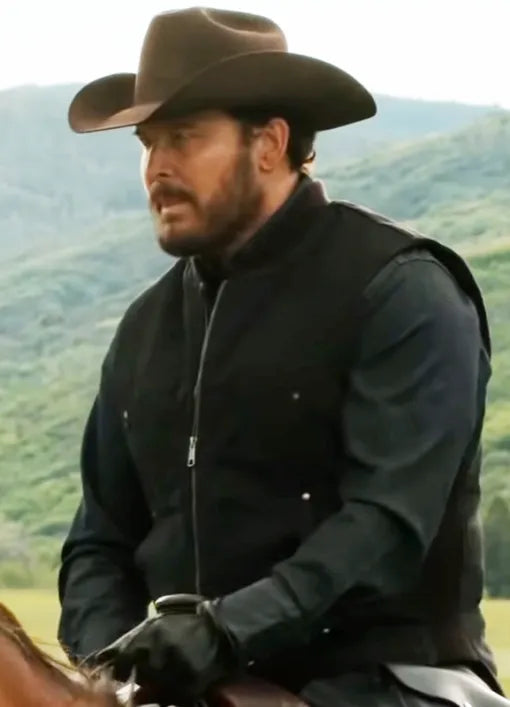 Yellowstone Rip Wheeler in a cowboy hat and black wool vest riding a horse with a scenic background