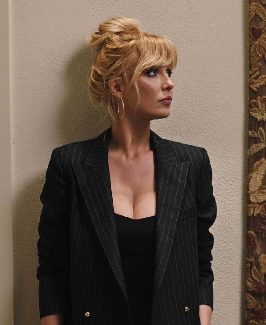 Beth Dutton wearing a black pinstripe blazer over a black top.