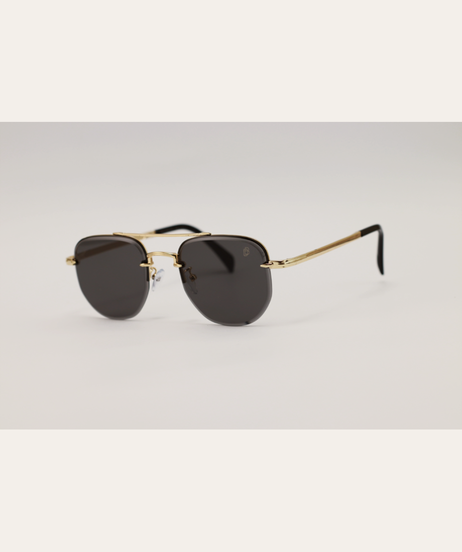 Rip Wheeler Sunglasses with gold frame and black lenses on a light gray background